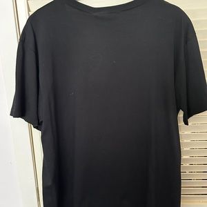 Black t-Shirt with orange colour and gold patch .
